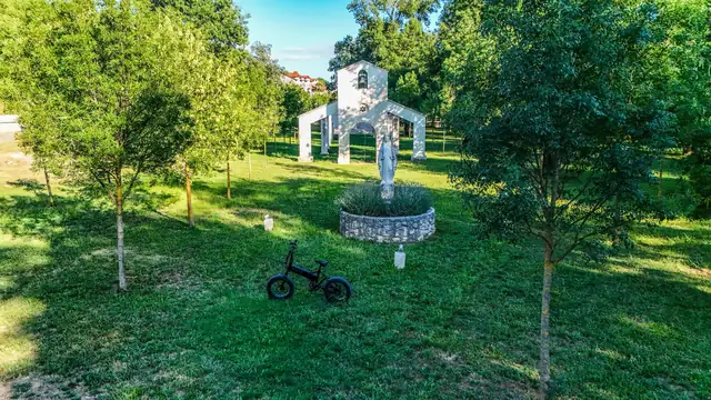 Mate.Bike in a park in front of a statue of Our Lady